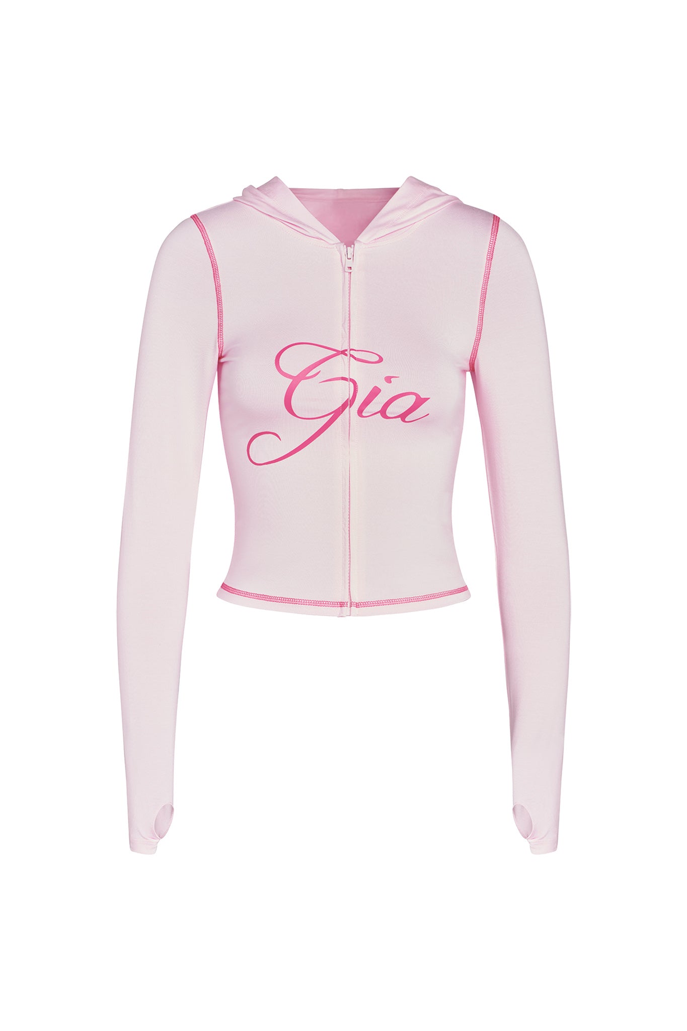 The BLARE HOODIE in pastel pink from I.AM.GIA is a light pink, long-sleeved, cropped hoodie made from stretchy bamboo fabric with a full front zipper. It features the name "Gia" in large cursive letters across the chest. The fabric appears soft and slightly elastic, with thumb holes at the sleeve cuffs for added comfort.