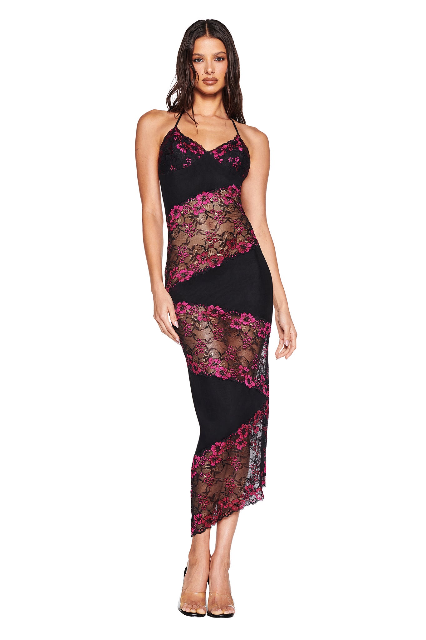 A woman models the I.AM.GIA PALOMA MIDI DRESS in black, a sleeveless fitted halter dress with diagonal sheer lace panels featuring pink floral patterns and an asymmetrical lace hem, posing against a white background.