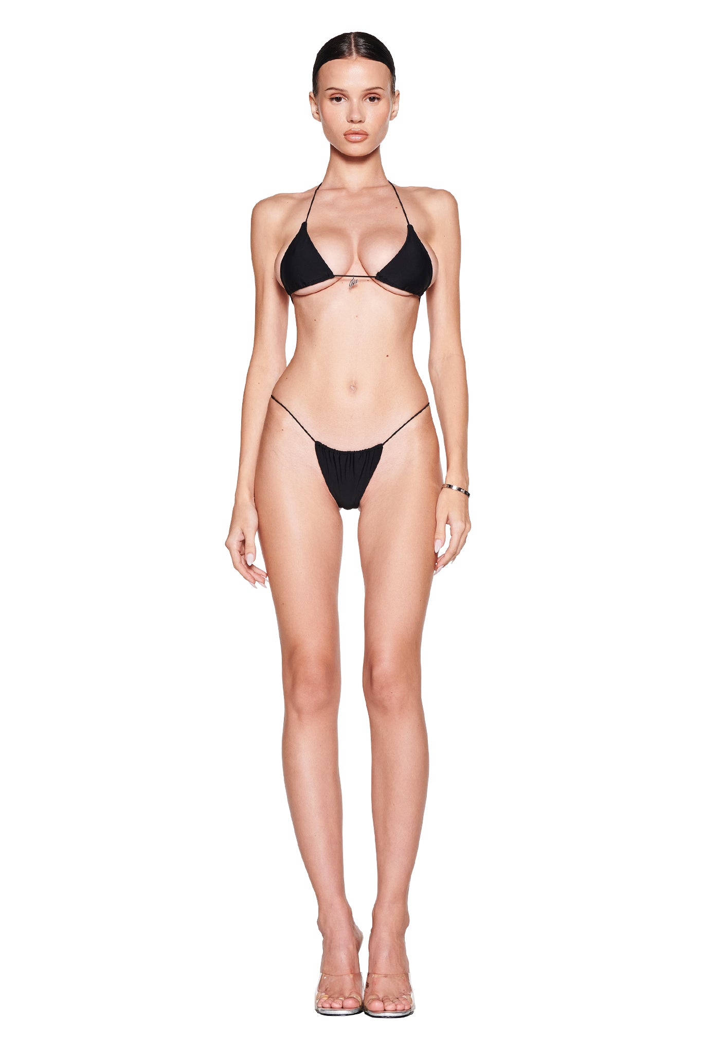 Wearing the I.AM.GIA BAMBI BIKINI TOP - BLACK, striking black fabric with silver hardware shines against a white background. The halter neck exudes chic confidence.
