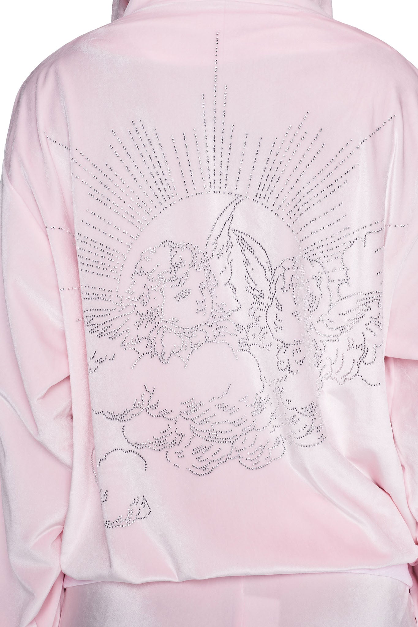 A close-up of the back of the I.AM.GIA DARIA HOODIE - PINK : ICY PINK showcases an intricate design of two cherubs among clouds, outlined with small rhinestones, beneath a radiant sunburst pattern. The fabric features a smooth, slightly glossy texture, adding a luxurious feel.