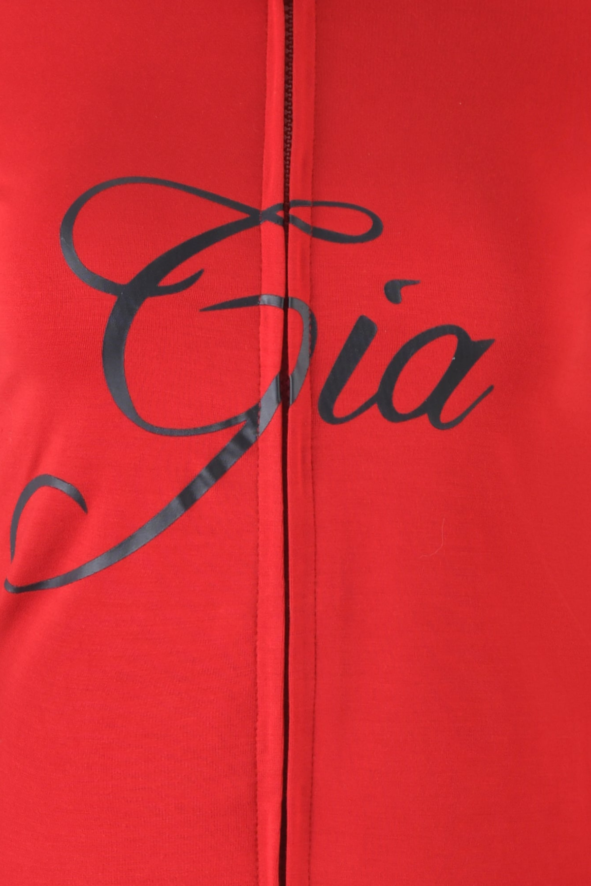 Close-up of red BLARE HOODIE by I.AM.GIA, featuring bamboo fabric with black script text reading “Gia.” A vertical seam runs through the center of the image.