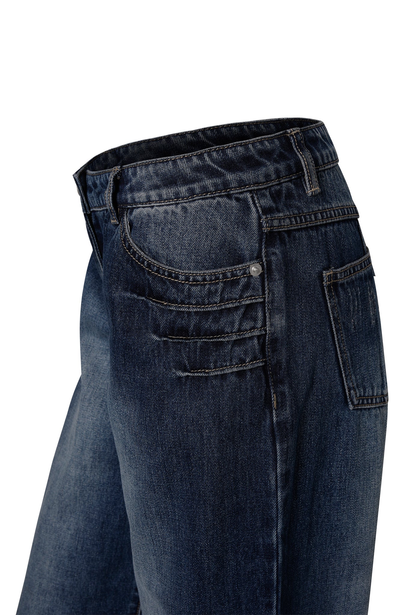 A close-up view of the I.AM.GIA DYLAN JEAN - BLUE in dark blue from the side, showcasing the waistband, front pockets, and side seam. The jeans feature visible stitching details and a slightly faded texture. The background is white.
