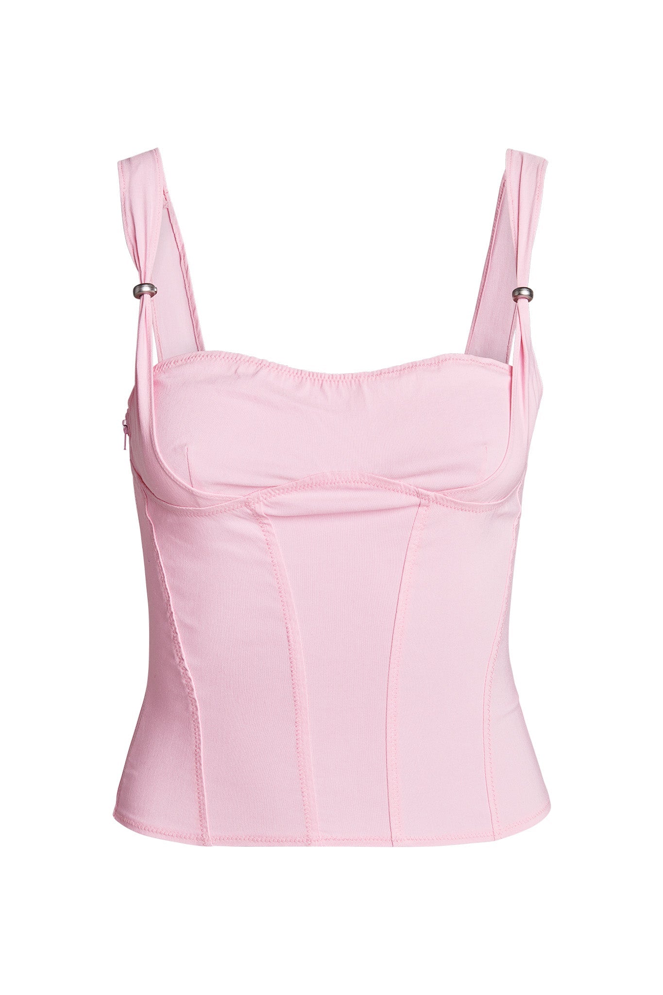 The IDEZ CORSET - PINK by I.AM.GIA is a light pink corset top with wide, adjustable straps and silver hardware. It features a fitted, structured design with seam detailing along the front and sides. The slightly stretchy fabric offers a snug yet comfortable bodycon fit.